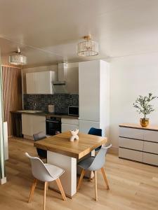 a kitchen and dining room with a wooden table and chairs at Le Faubourg St Martin Gold&Green in Senlis