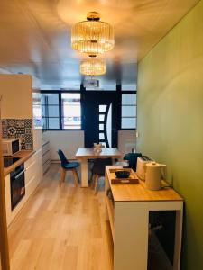 a kitchen with a table and a dining room at Le Faubourg St Martin Gold&Green in Senlis +34 photos