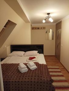 a bedroom with a bed with two towels on it at Pensiunea IULIA in Rod