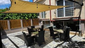 a patio with tables and chairs and a yellow umbrella at Apartments Philip II in Ohrid