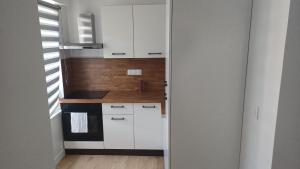 a small kitchen with white cabinets and a stove at Appartement lena in Boulogne-sur-Mer