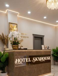 a hotel skyhouse reception desk with flowers and a chandelier at SkyHouse Batumi in Batumi +22 photos