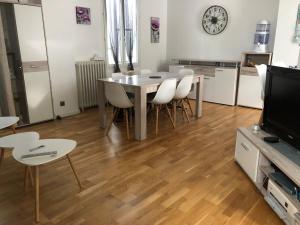 a dining room with a table and chairs and a television at Villa avec Piscine in Brive-la-Gaillarde