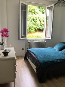 a bedroom with a blue bed and a window at Villa avec Piscine in Brive-la-Gaillarde +8 photos