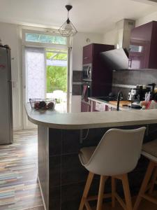 a kitchen with a counter and a white chair at Villa avec Piscine in Brive-la-Gaillarde