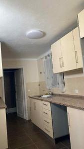 a kitchen with white cabinets and a counter top at Lajes guests house in Lajes