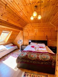a bedroom with a bed in a wooden cabin at Pensiunea IULIA in Rod