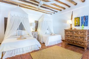 two beds in a bedroom with white walls at Ser Casasandra Boutique Hotel in Holbox Island +60 photos