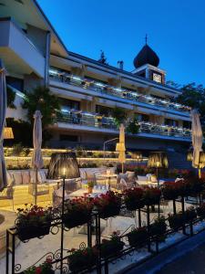 a hotel with tables and chairs and umbrellas at OLEO hotel in Momchilgrad