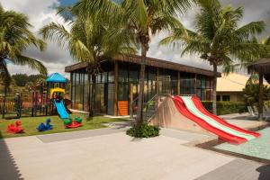 a playground in front of a building with palm trees at Vila Galé Resort Cumbuco - All inclusive in Cumbuco