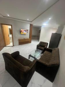 a living room with a couch and a glass table at best standing with ascenceur in El Jadida