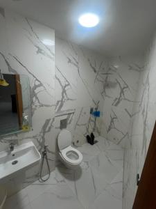 a white bathroom with a toilet and a sink at best standing with ascenceur in El Jadida