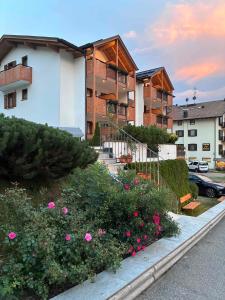 a building with pink flowers in a parking lot at Residence Cima Tosa in Andalo