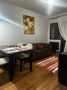 a living room with a table and a couch at Apartamento Saint Moritz flat service in São Bernardo do Campo