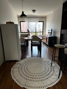 a living room with a refrigerator and a table and chairs at Apartamento Saint Moritz flat service in São Bernardo do Campo