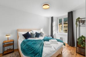 a bedroom with a bed with a blue blanket on it at Chez Fridolin in Glarus