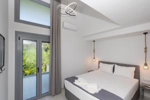 a bedroom with a bed and a large window at Verde Villas in Skala Potamias +52 photos