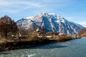 a mountain in front of a river with snow at Chez Fridolin in Glarus