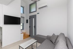 a living room with a couch and a tv at Verde Villas in Skala Potamias
