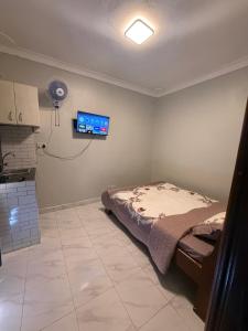 a bedroom with a bed and a tv on the wall at Crown Motel Lugala in Kampala