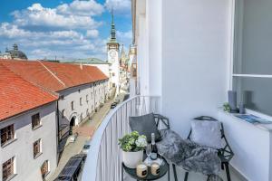 a balcony with a view of a clock tower at Apartmány Prusinovského in Kroměříž