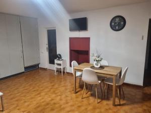 a dining room with a table and chairs and a clock at Appartement Cambrils in Cambrils