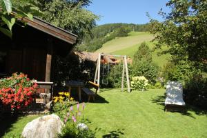 a garden with a bench and a gazebo at Appartements Haus Bachmann in San Candido
