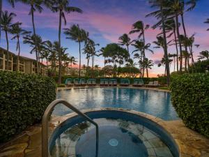 a pool at a resort with palm trees at Villa 102 at Turtle Bay in Kahuku