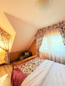 a bedroom with a bed and a chair and a window at Zoloche Chalet in Vishenki