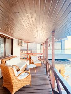 a wooden deck with wicker chairs and tables on a boat at Zoloche Chalet in Vishenki