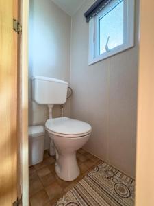 a bathroom with a toilet and a window at Motyl in Doba