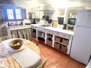 a kitchen with a table and a white refrigerator at 2-Bed Country House - Mountain Views - Sleeps 6 in Rute