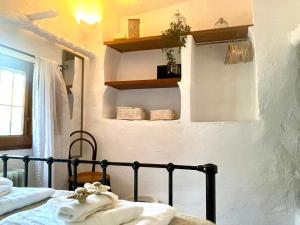 a bedroom with a bed and shelves on the wall at 2-Bed Country House - Mountain Views - Sleeps 6 in Rute +16 photos