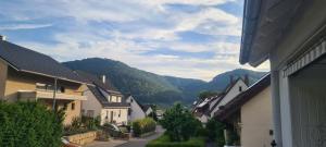 a town with houses and mountains in the background at Apartment Am Tobelbach in Oberlenningen