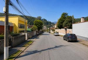 an empty street with cars parked on the side of the road at Casa da Marquês in Petrópolis