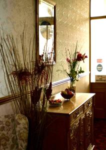 een dressoir met twee vazen bloemen erop met een spiegel bij Gifford House in Edinburgh