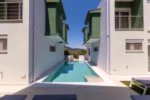 a view of a swimming pool between two buildings at Verde Villas in Skala Potamias