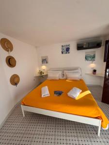 a bedroom with a bed with an orange blanket at Il Nido del Gabbiano in Vietri sul Mare +26 photos