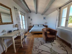 a bedroom with a bed and a table and chairs at Chambres d'hôtes - Chez Stephane in L'Ile d'Yeu