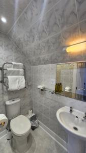 a white bathroom with a toilet and a sink at Corriemar House in Oban +49 photos