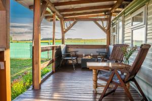a deck with chairs and tables on a house at Motyl in Doba +4 photos