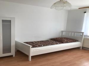 Łóżko w pokoju z białymi ścianami i sufitem w obiekcie White House Bochum II w mieście Bochum
