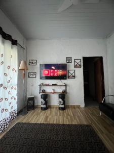 a living room with a tv on a wall at Chácara dos Silva in Santa Isabel