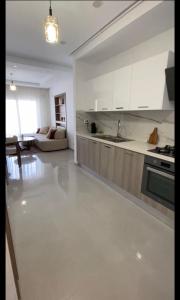 a kitchen with white cabinets and a living room at Appartement S2 résidence costa '0751' 8402'79 fr in El Ahmar