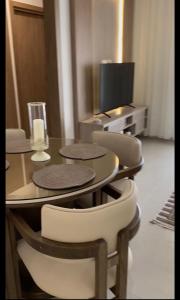 a dining room with a table and chairs and a tv at Appartement S2 résidence costa '0751' 8402'79 fr in El Ahmar