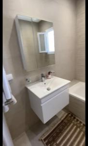 a bathroom with a sink and a tub and a mirror at Appartement S2 résidence costa '0751' 8402'79 fr in El Ahmar +13 photos
