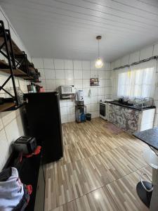 an empty room with a kitchen and a wooden floor at Chácara dos Silva in Santa Isabel +11 photos