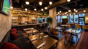a restaurant with tables and chairs and a bar at Kimpton Saint George Hotel by IHG in Toronto