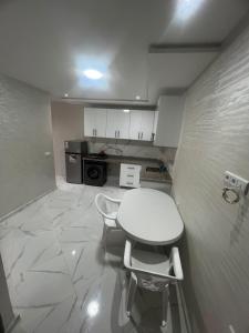 a small kitchen with a white table and chairs at relaxtime avec ascenceur in El Jadida