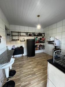 a large kitchen with a counter and a refrigerator at Chácara dos Silva in Santa Isabel